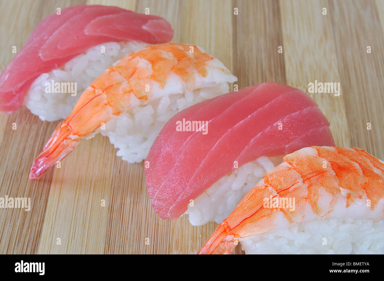 Thunfisch und Garnelen Sushi diagonal in einer Reihe auf Bambus Stockfoto