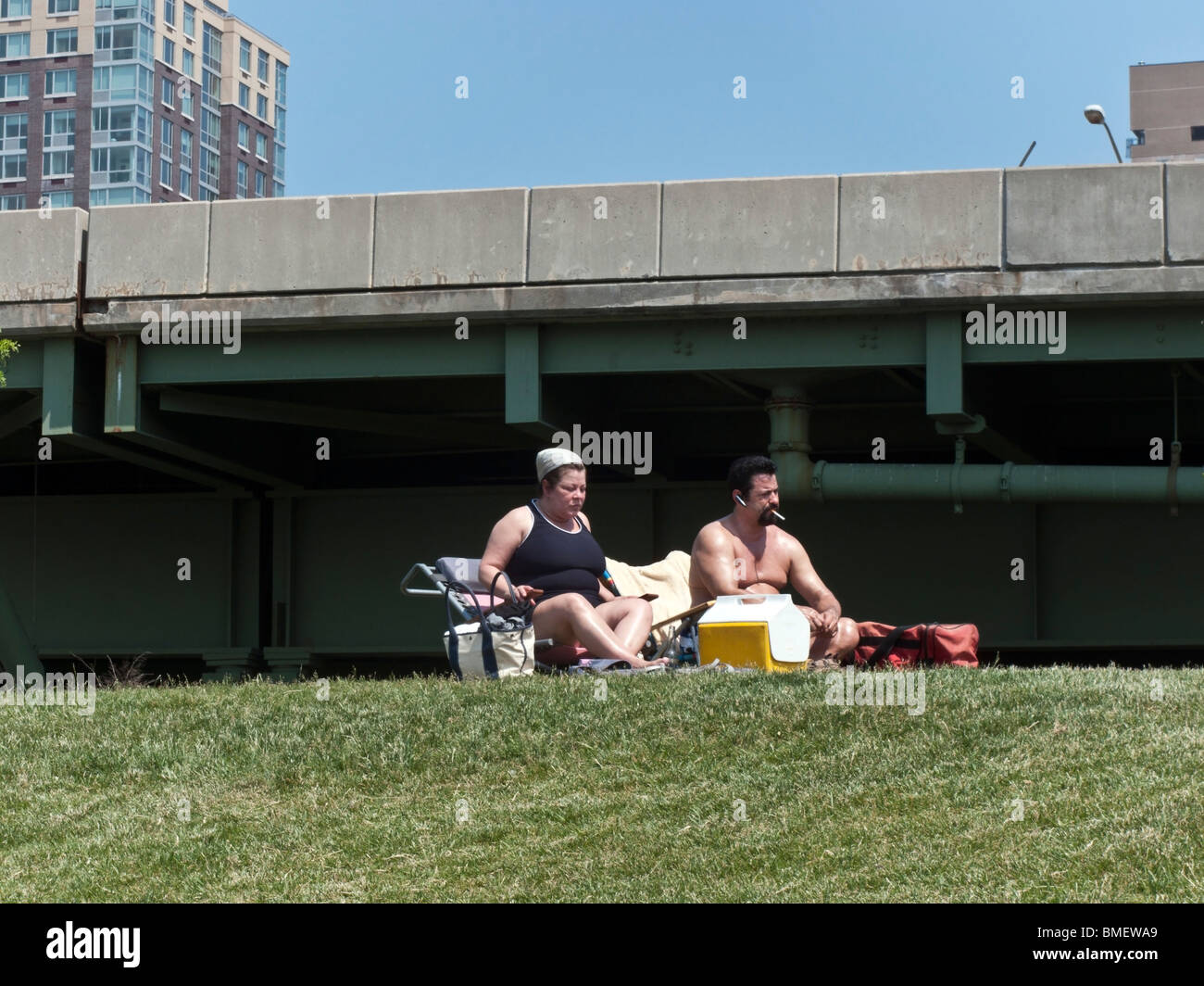 klobige paar wählen Sie einen Ort auf Grashügel neben West Side Highway für ihren Gedenktag Ausflug im Riverside Park New York Stockfoto