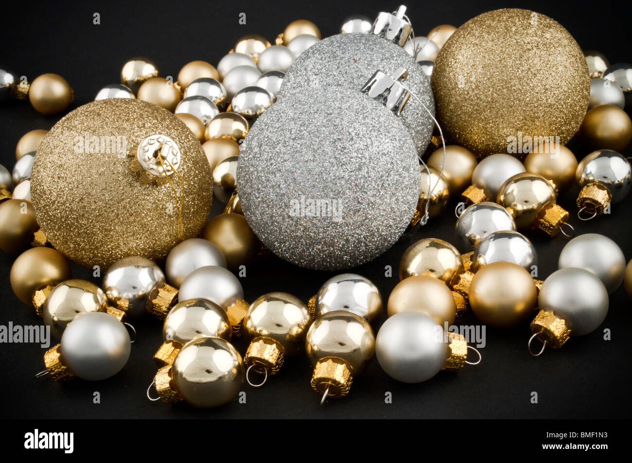 Volle Packung von silbernen und goldenen Weihnachtskugeln auf schwarz Stockfoto