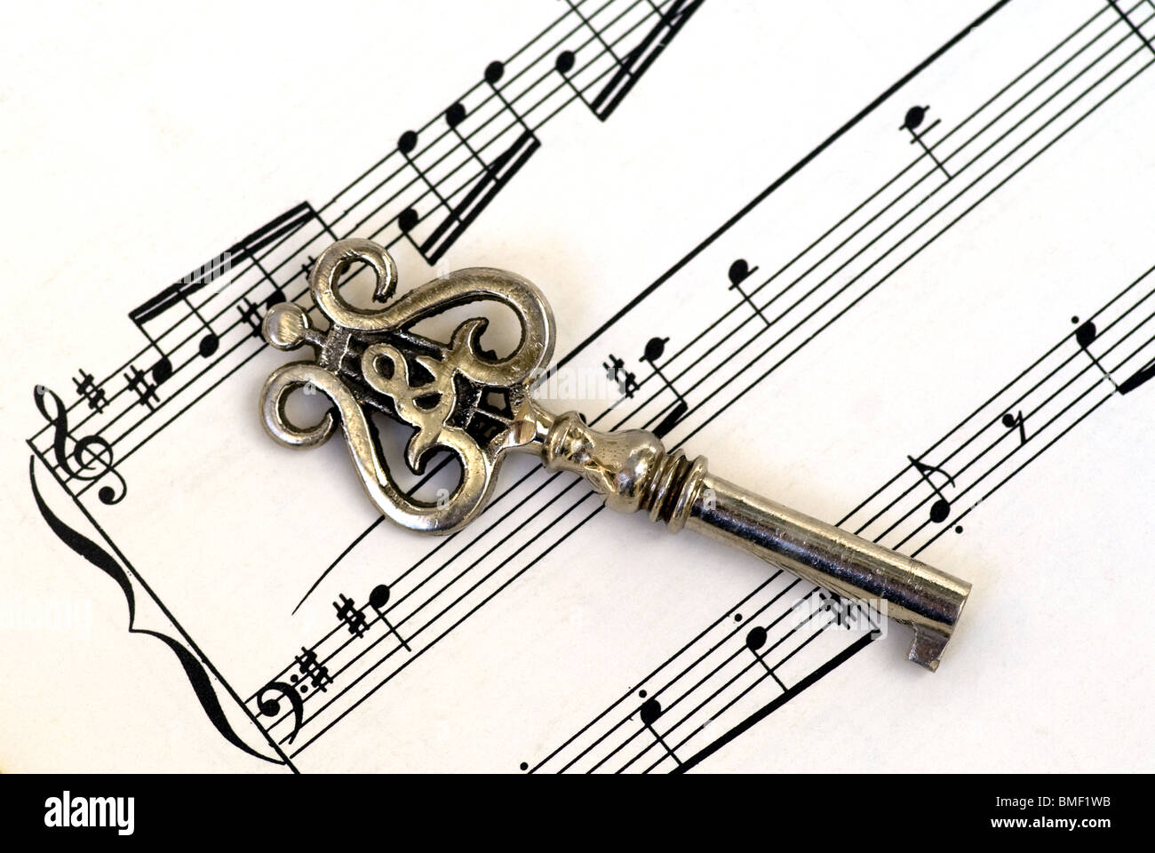 Antiker Violinschlüssel auf einer Seite mit Notenblättern, die in einem Winkel in einer Nahaufnahme platziert sind. Stockfoto
