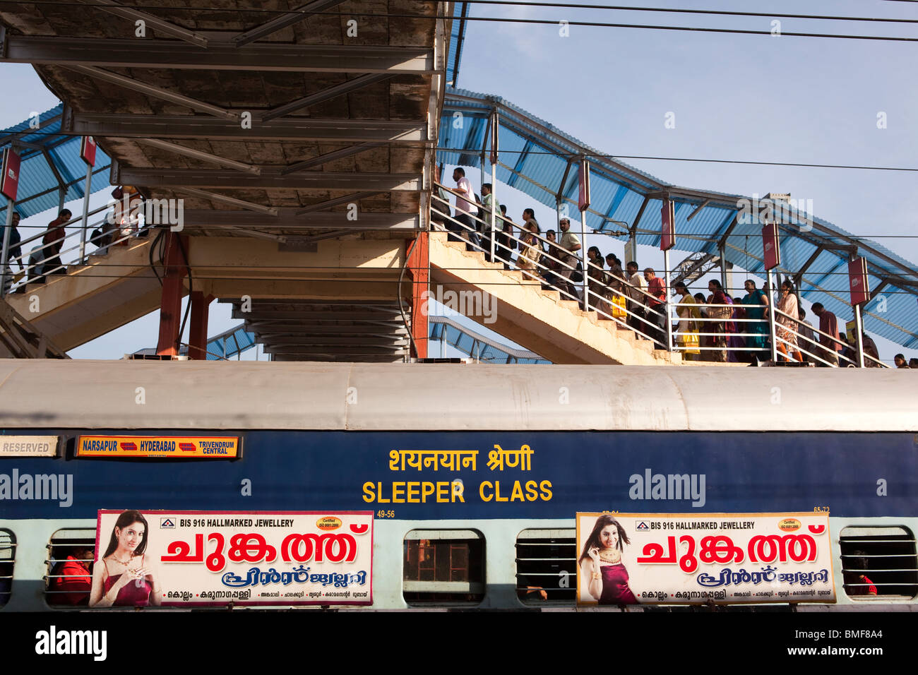 Indien, Kerala, Kollam Junction Railway Station, Passagiere auf Fußgängerbrücke überqueren Linie Stockfoto