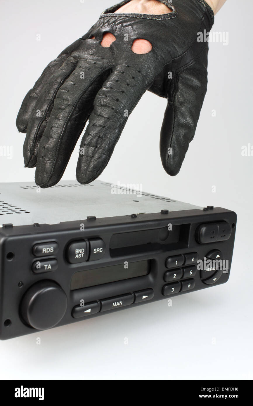 behandschuhten Hand des Diebes erreicht für ein Autoradio - Auto-Stereo-Diebstahl-Konzept Stockfoto