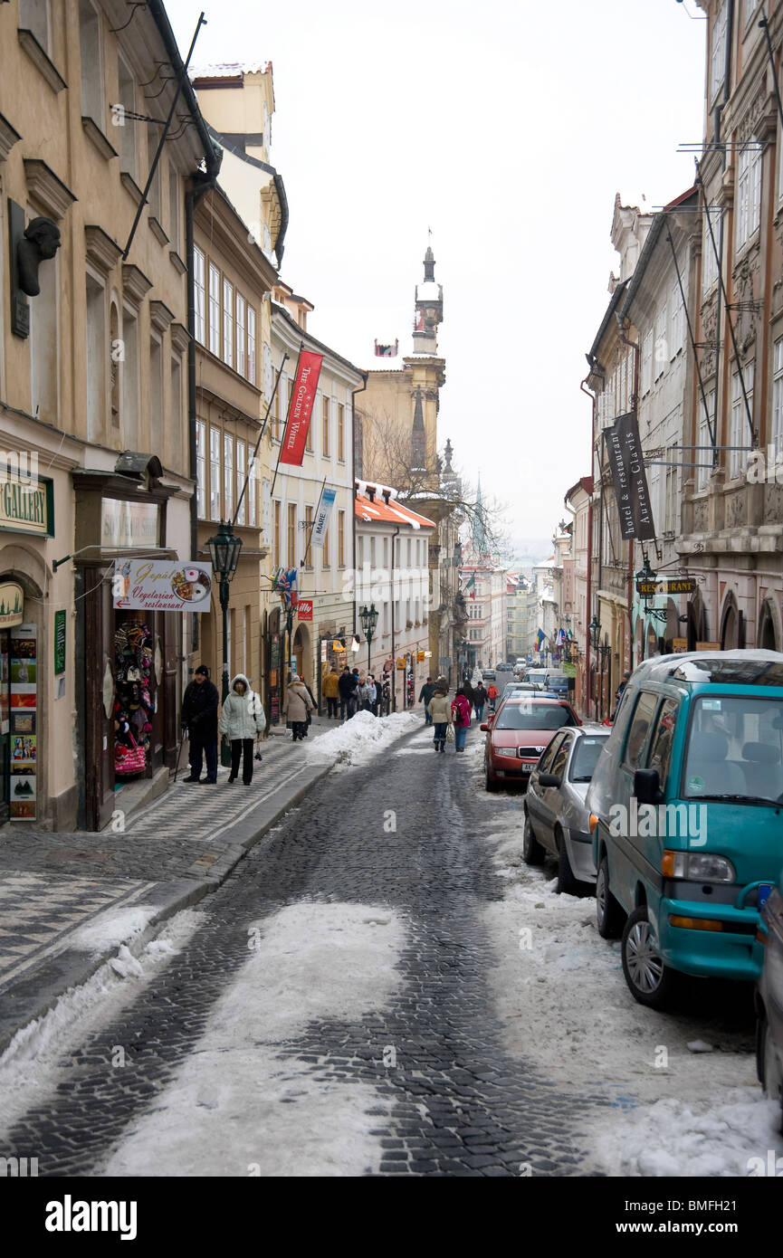 Verschneite Straße im Zentrum von Prag, schmal mit parkenden Autos Stockfoto