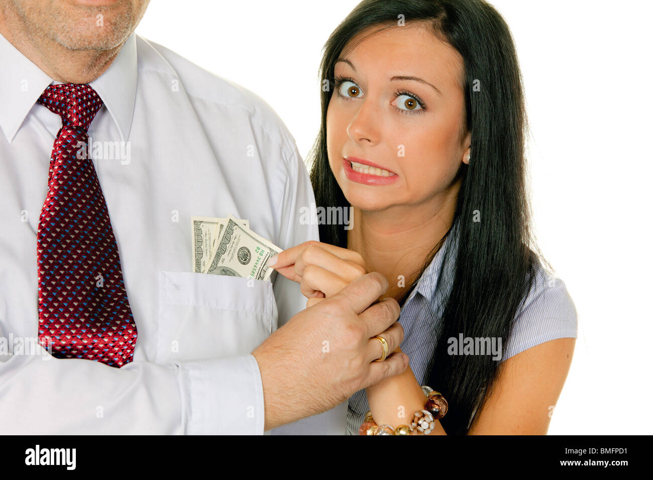 Eine junge Frau zieht das Geld aus der Tasche eines Mannes. Dollar Stockfoto