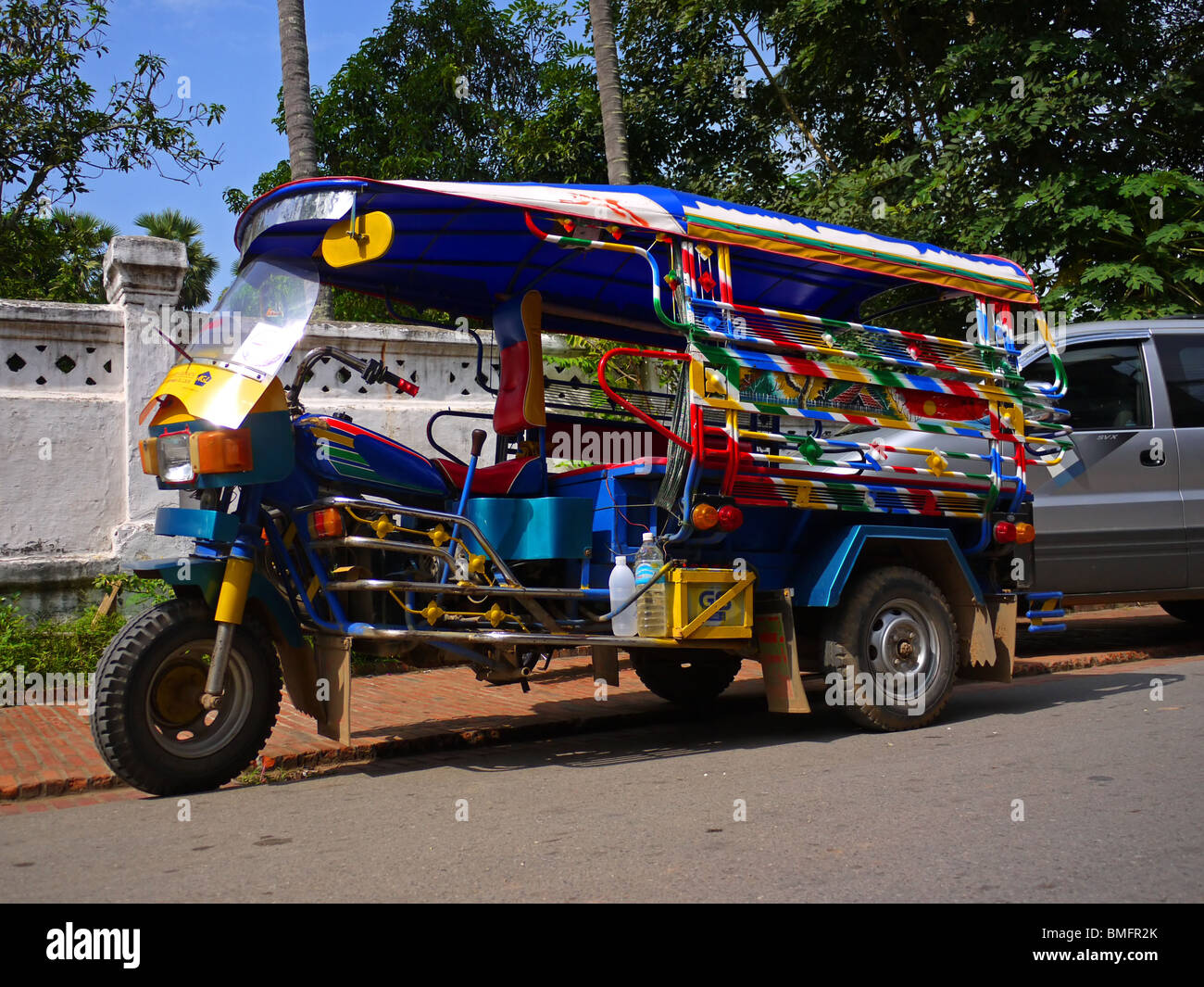 Asiatische Pkw Dreirad (allgemein bekannt als Tuk-Tuk oder Tuc-Tuc) geparkt in der Seitenstraße in Luang Prabang, Nordlaos Stockfoto