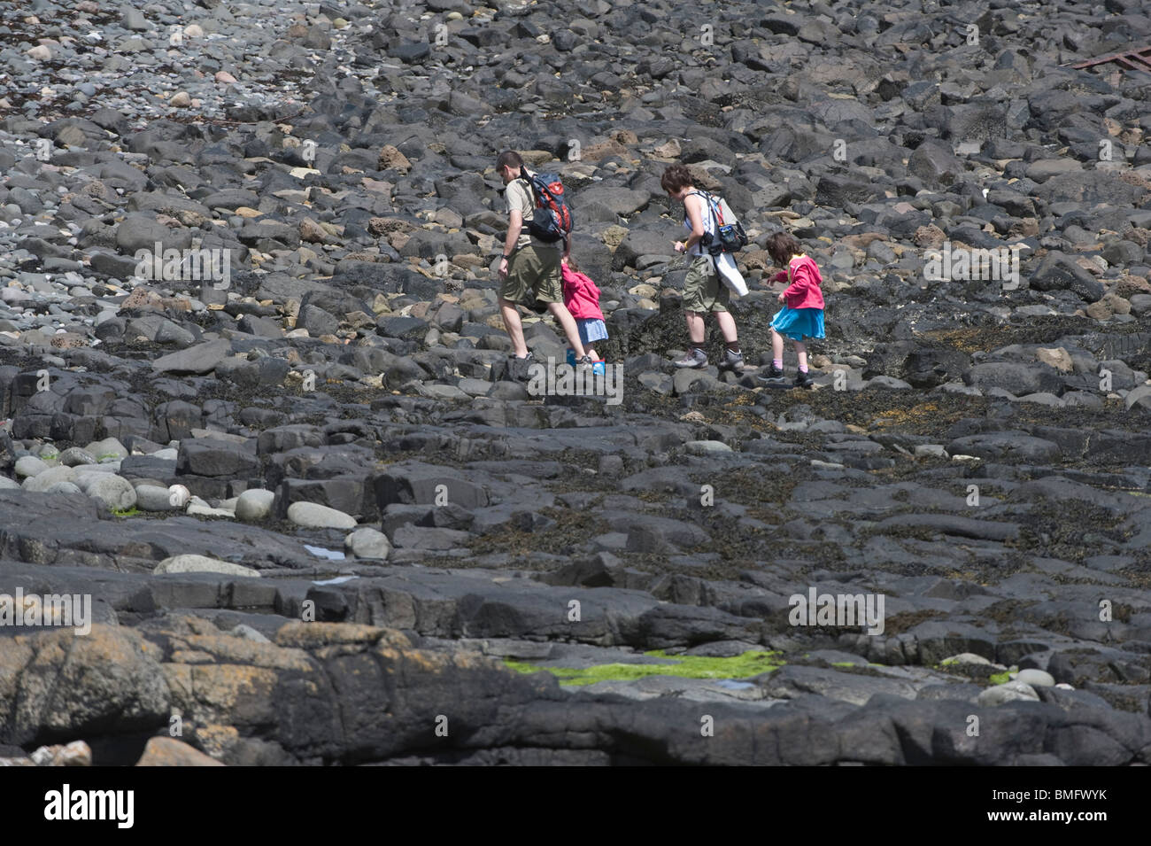 Familie mit zwei Kindern zu Fuß auf Felsen in der Nähe von Dunstanburgh Castle Craster Northumberland Küste England UK Europe Stockfoto