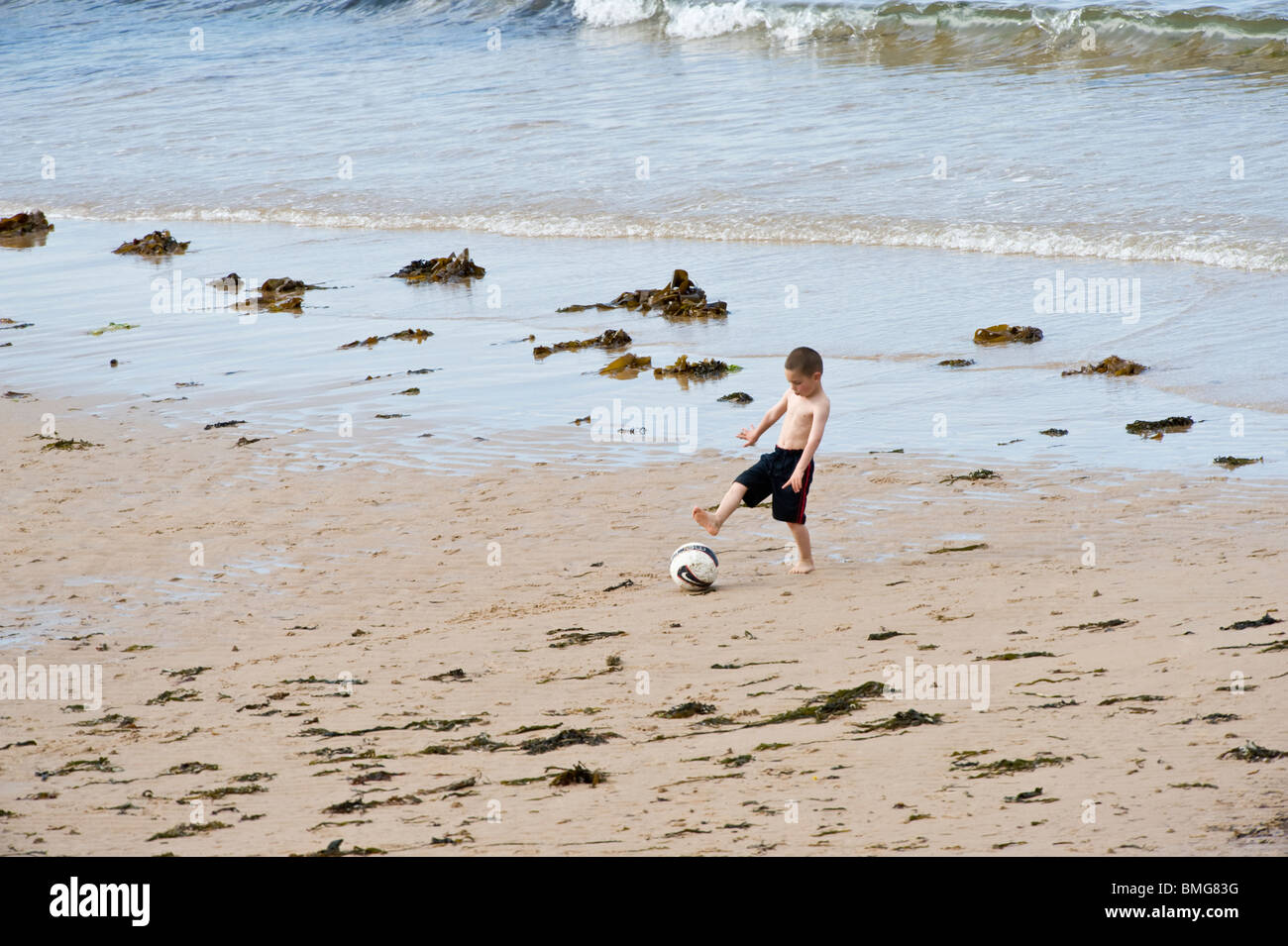 Junge mit Ball Embleton Bay Northumberland England UK Europa Juni spielen Stockfoto