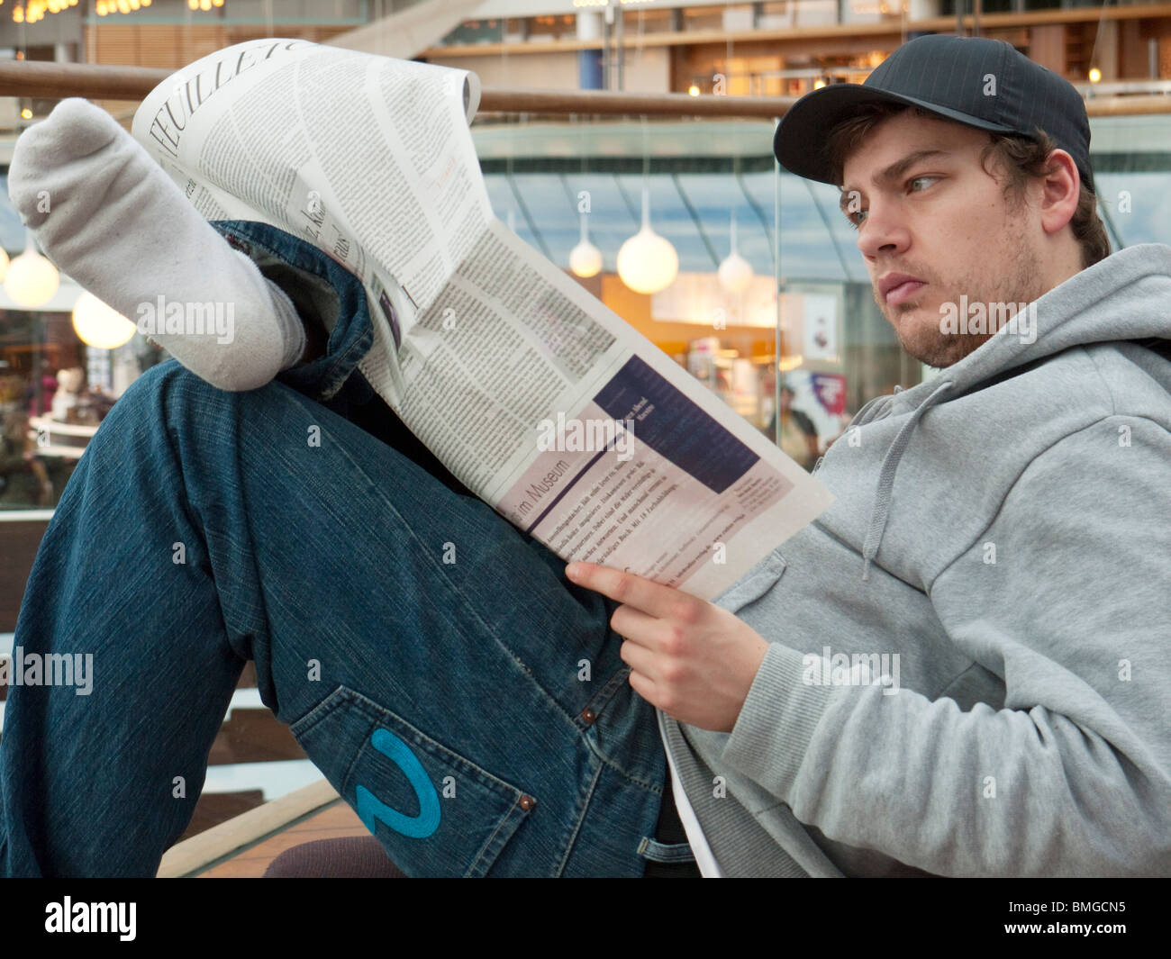Ein Schüler liest eine Zeitung auf dem Flughafen Stockholm-Arlanda. Stockfoto