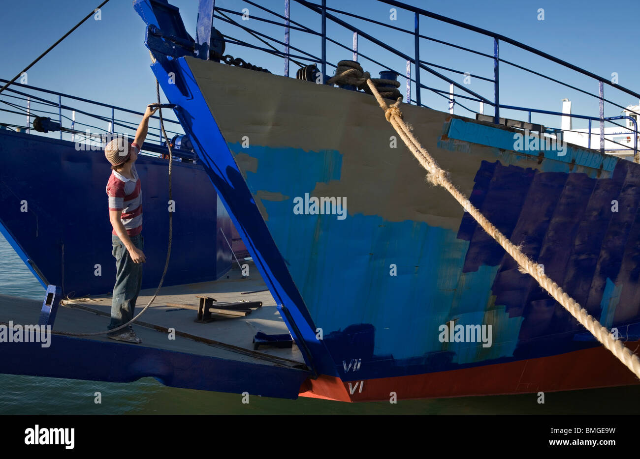 Ein Hafenarbeiter Malerei ein Schiffsrumpf, Auckland, Neuseeland Stockfoto