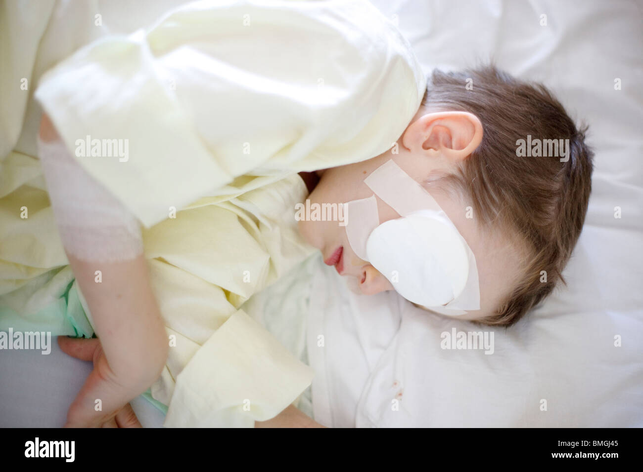 fünf Jahre alter Junge im Krankenhausbett liegen nach der Augenoperation Stockfoto