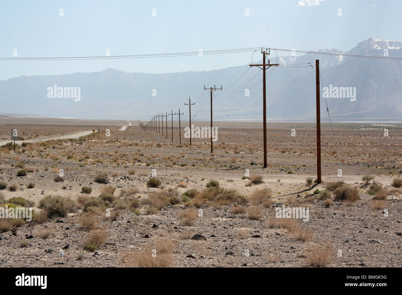 Linie von Telegrafenmasten, die in der Ferne in einer riesigen Kalifornische Wüste verschwindet Stockfoto