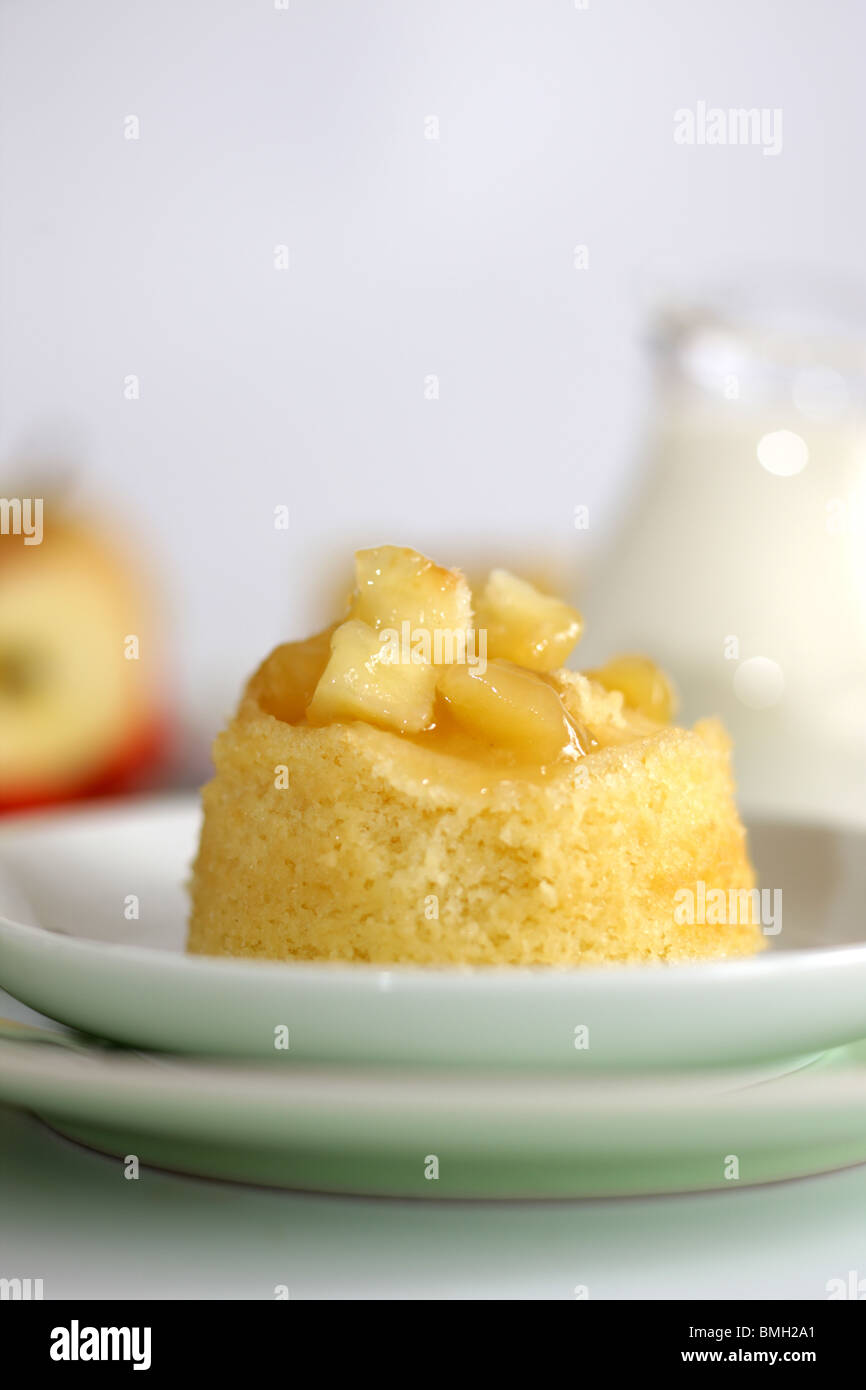 Traditionelle authentische britische's Dessert Eve Pudding mit Apfelkompott vor einem weißen Hintergrund und kein Volk Stockfoto
