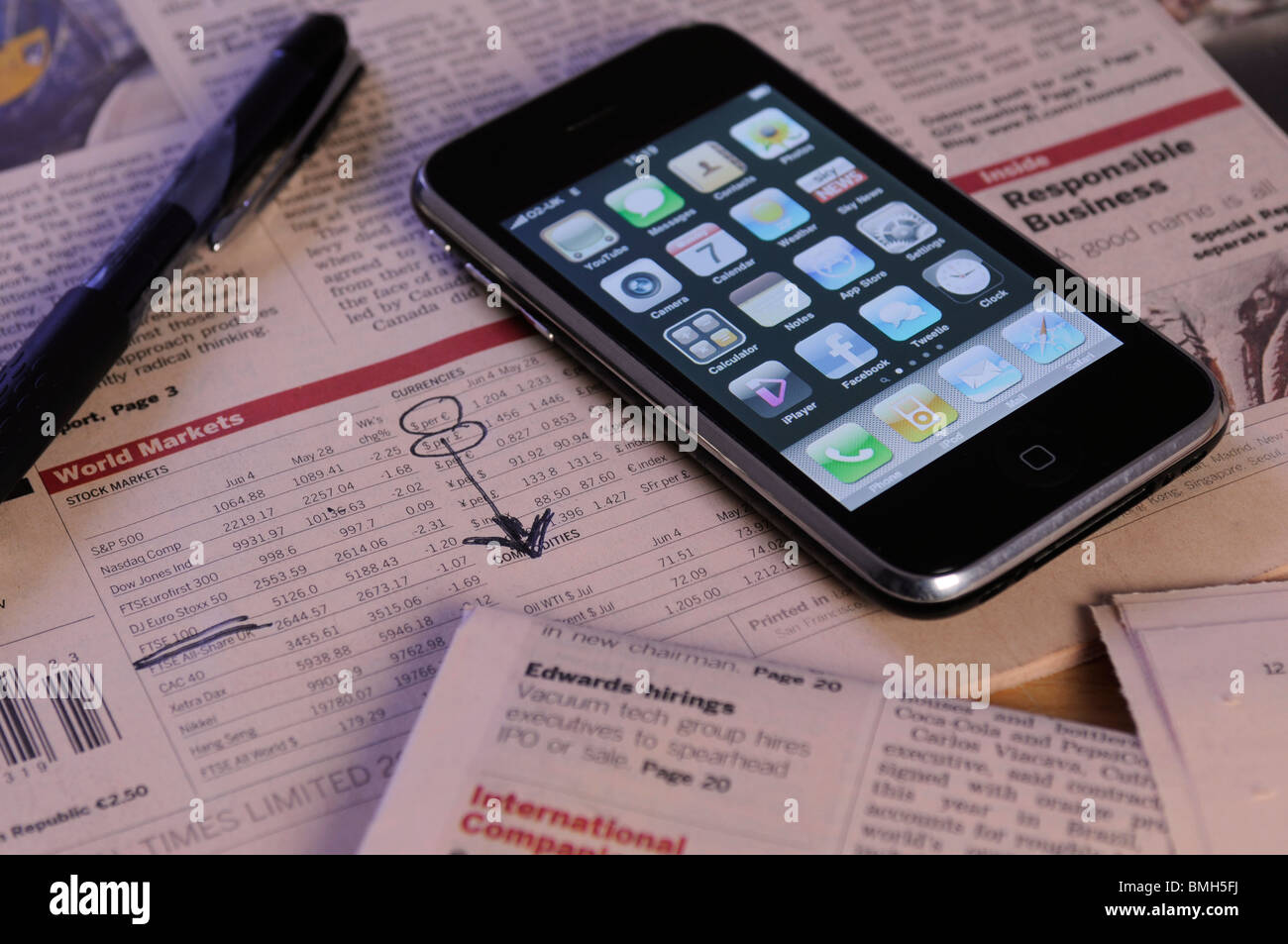 ein Iphone mit einer Zeitung, Aktien und Aktienkurse anzeigen Stockfoto