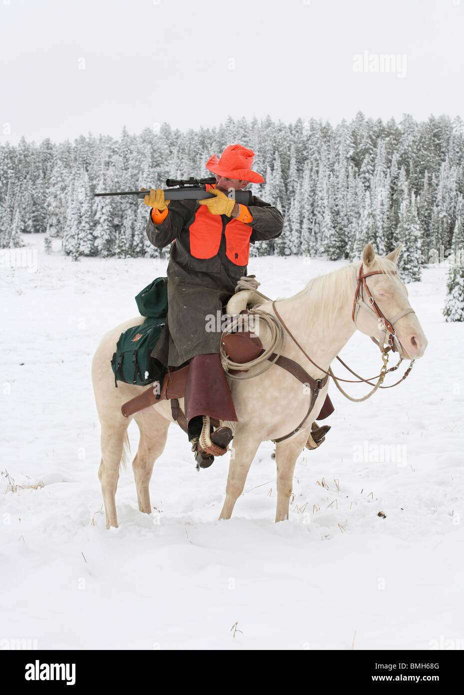 Deer Hunter White Reitpferd im Schnee mit dem Ziel, Gewehr Stockfoto