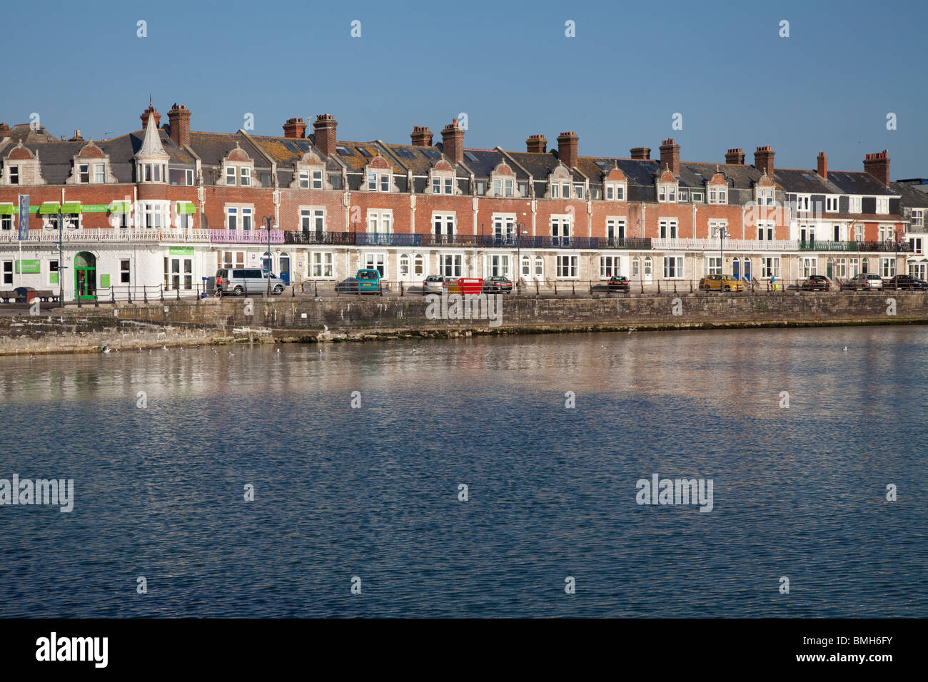 Promenade, Deich, Slipanlage und steinernen Buhnen bei Swanage in der frühen Morgensonne Stockfoto
