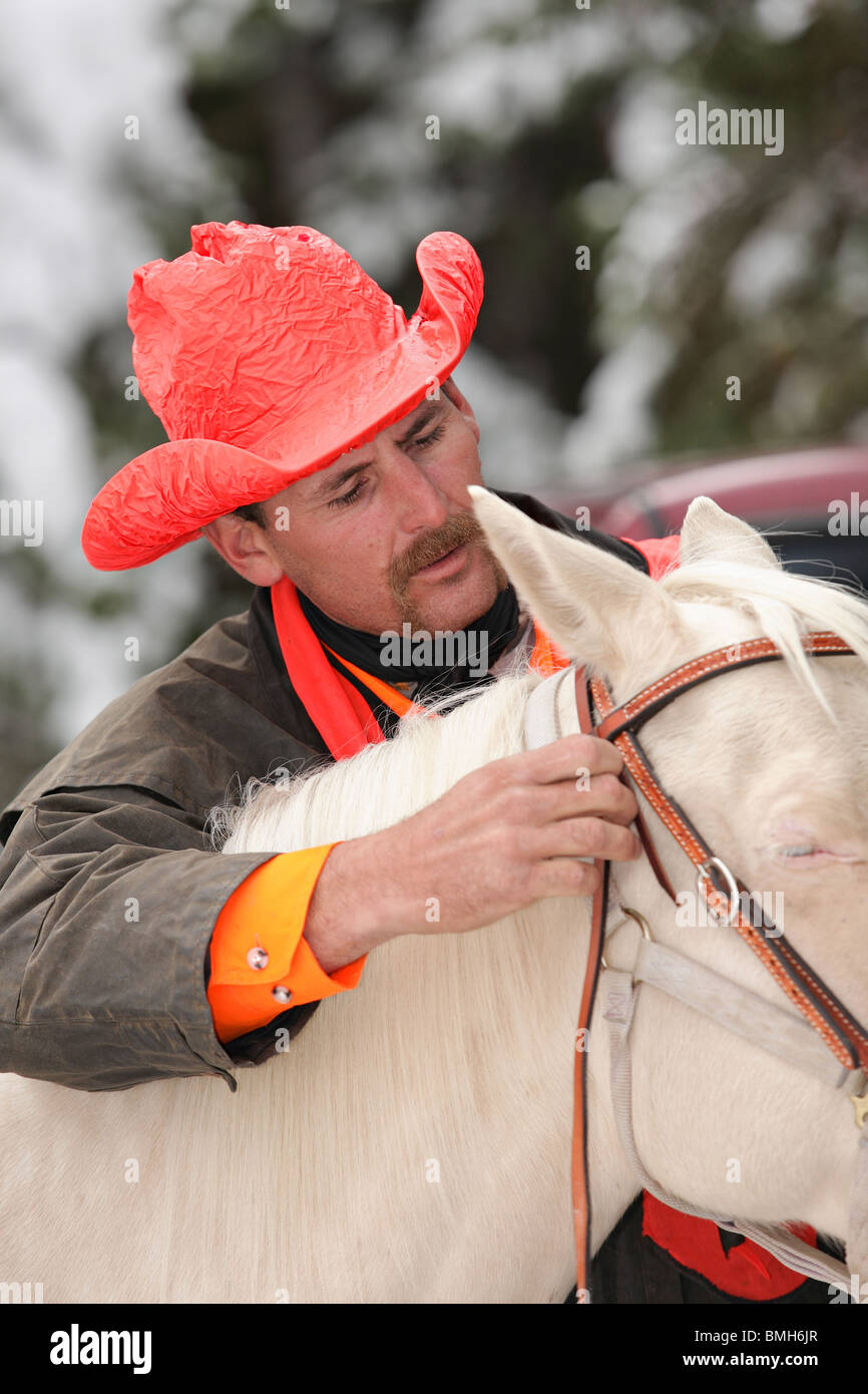 Nahaufnahme des schönen Cowboy Jäger immer weißes Pferd zum Reiten bereit Stockfoto