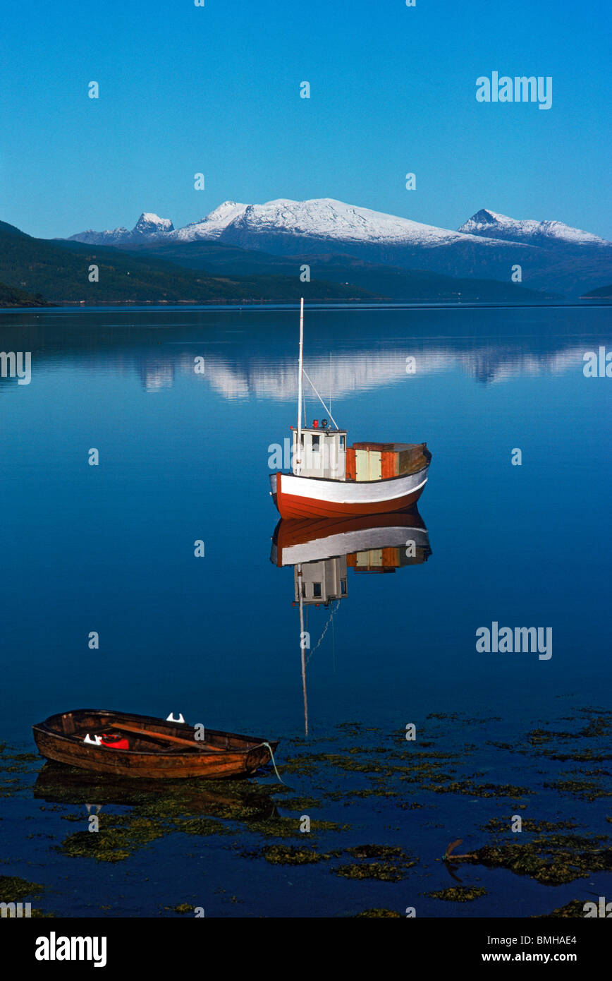 Kleines Fischerboot verankert im norwegischen Fjord mit kleinen Ruderboot Stockfoto