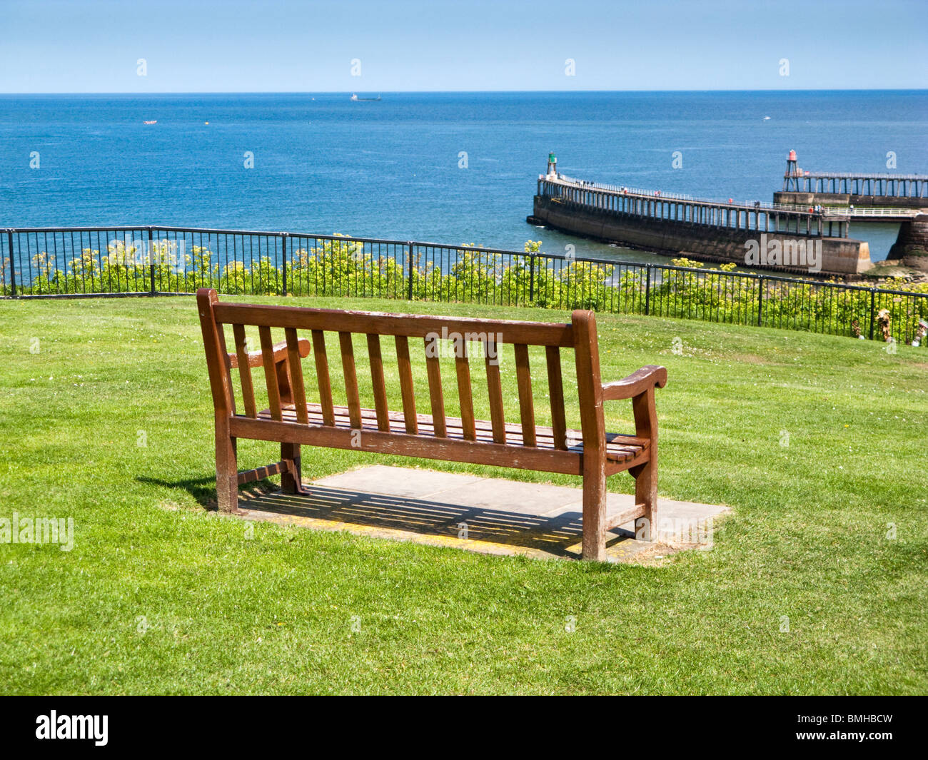 Parkbank mit Blick auf das Meer und die Pier in Whitby, North Yorkshire, England, UK Stockfoto