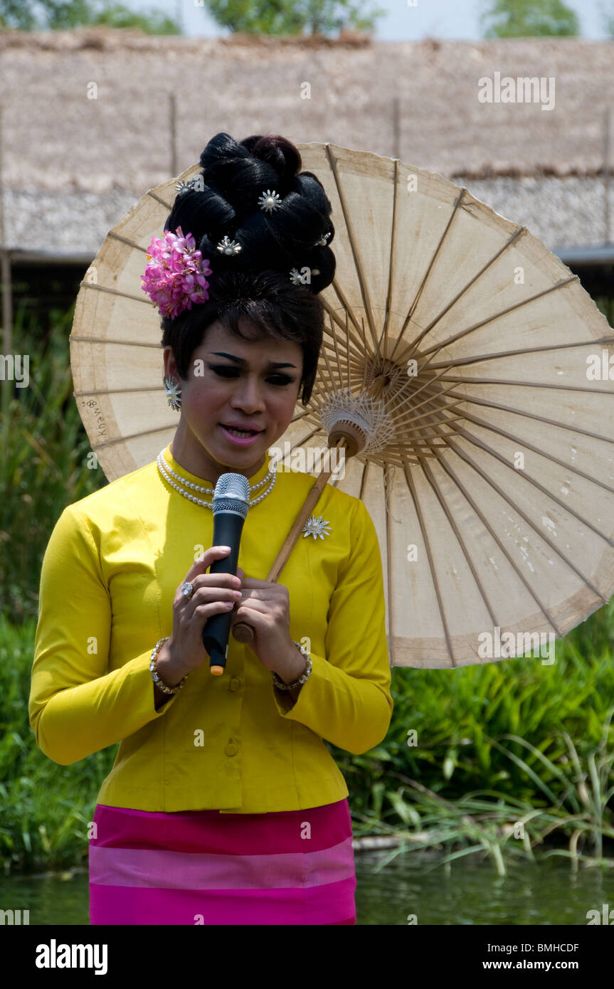 Leistung der Ladyboy Sängerin hält Regenschirm im freien Wasser Theatre, Klong Sra Bua schwimmenden Markt, Ayutthaya, Thailand. Stockfoto