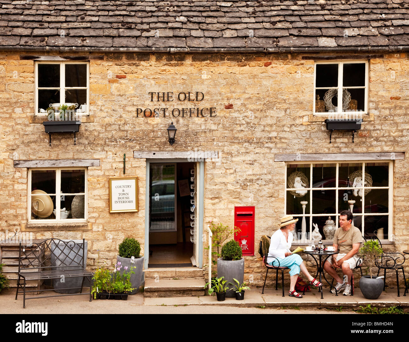 Ein paar beim Tee außerhalb der alten Post in Gloucestershire Cotswold Dorf Guiting Power, England, Großbritannien Stockfoto