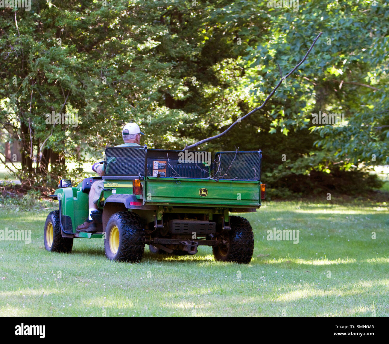 Ein Gärtner fahren einen Geländewagen Garten Nutzfahrzeug John Deere. Stockfoto