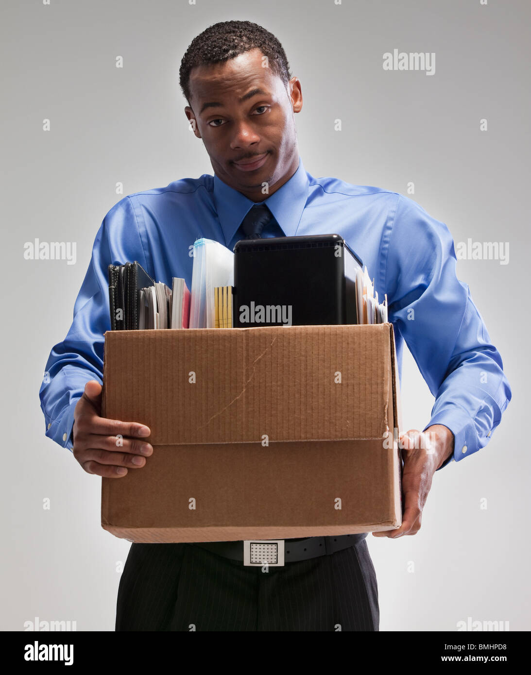 Geschäftsmann hält eine Schachtel mit Büromaterial Stockfoto