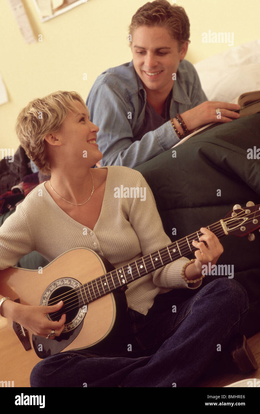 Mann, der Freundin spielen Gitarre zuhört Stockfoto