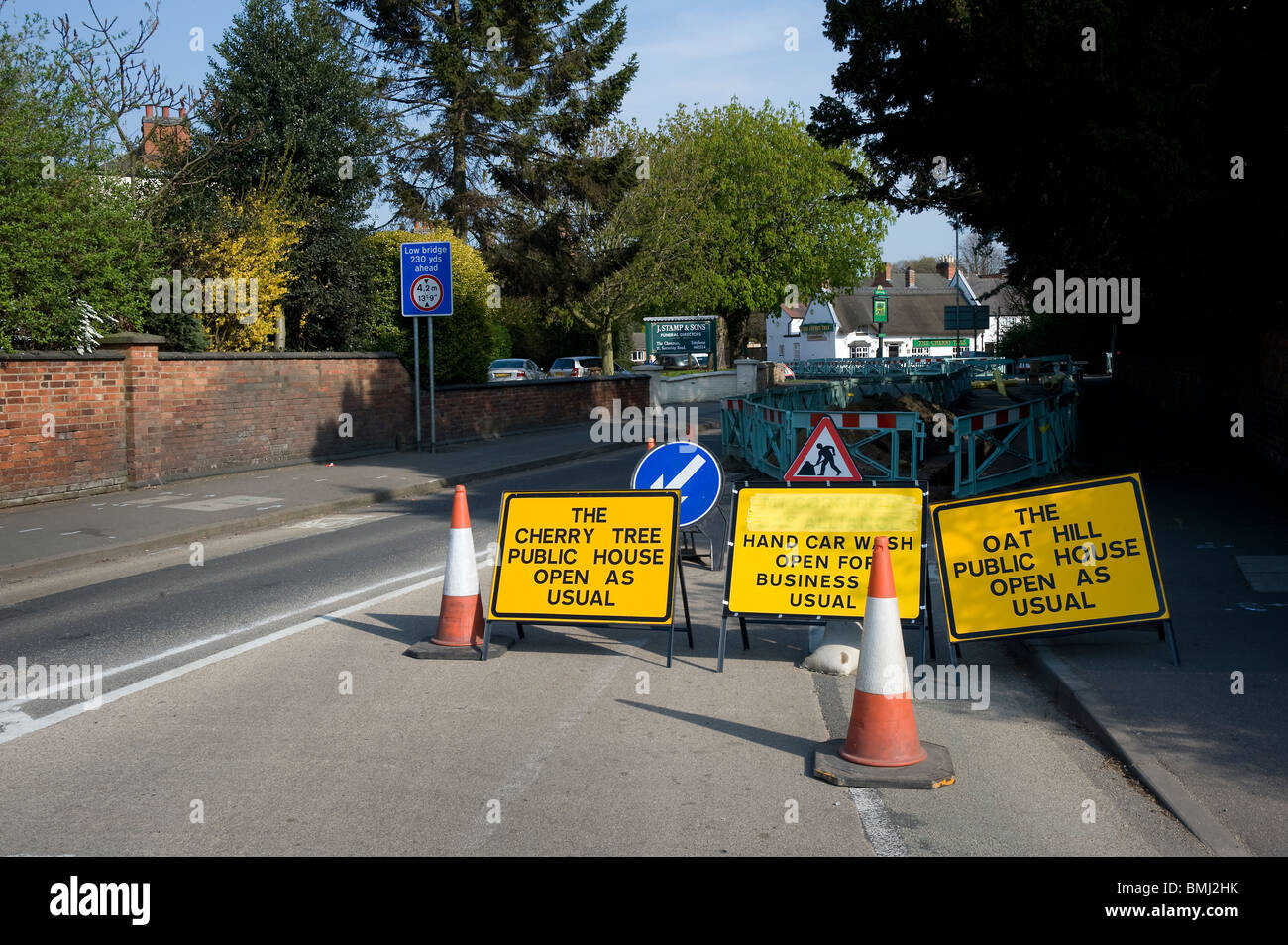 Verkehrszeichen, Zapfen und Barrieren um Baustellen auf einer Straße in England. Stockfoto