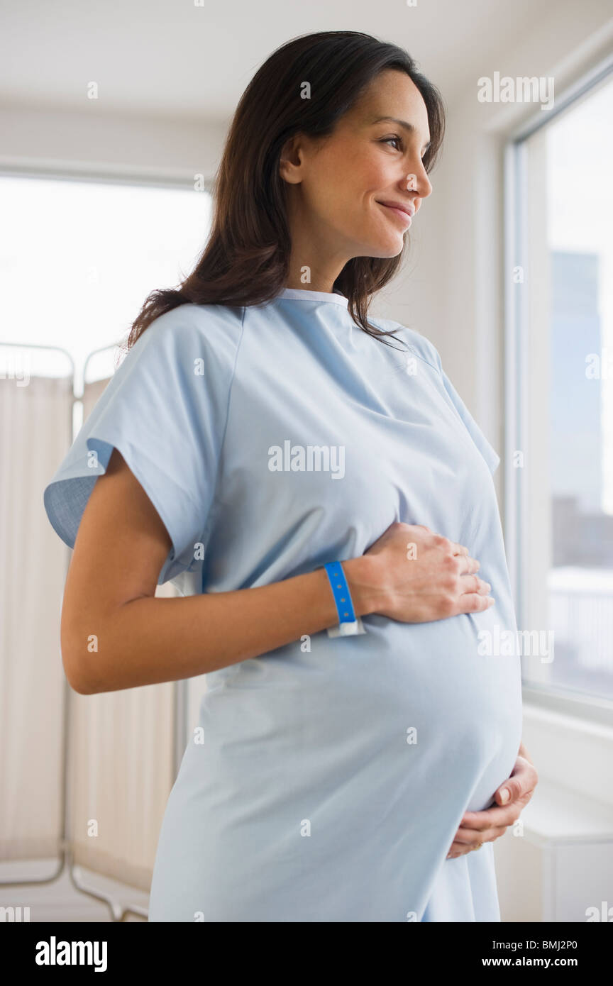 Schwangere Frau tragen Krankenhemd Stockfoto