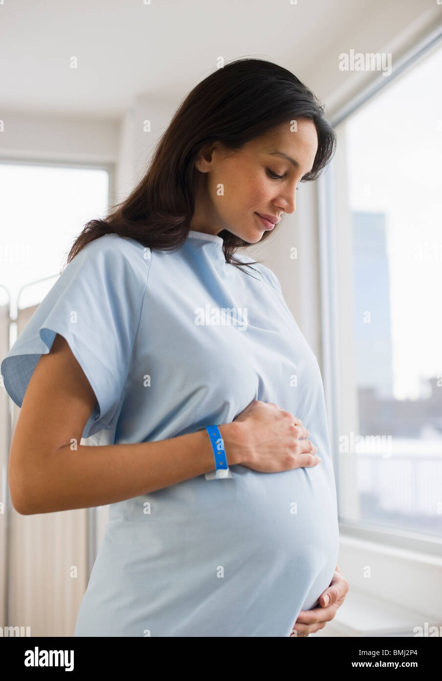 Schwangere Frau tragen Krankenhemd Stockfoto