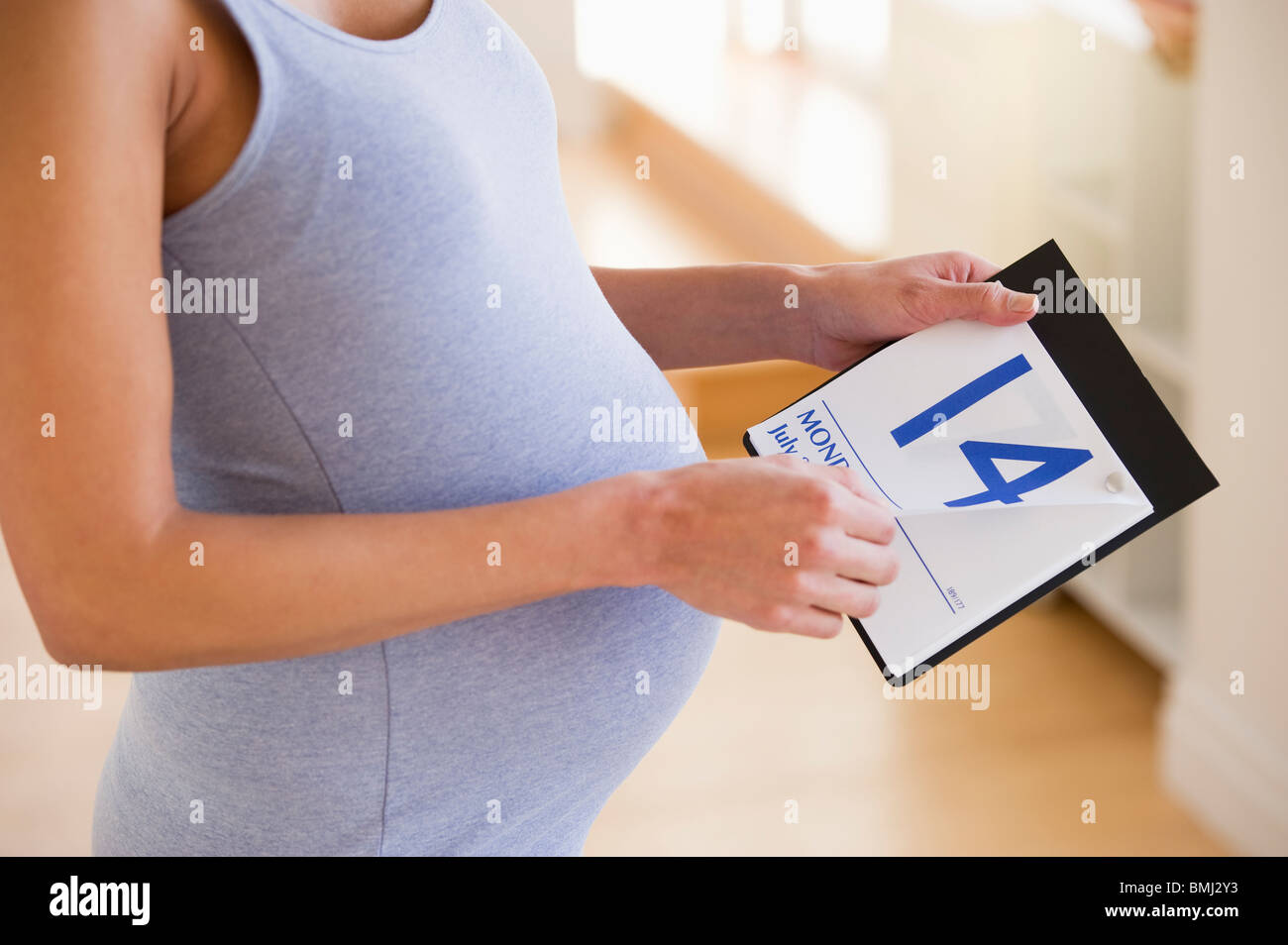 Schwangere Frau sucht einen Kalender Stockfoto