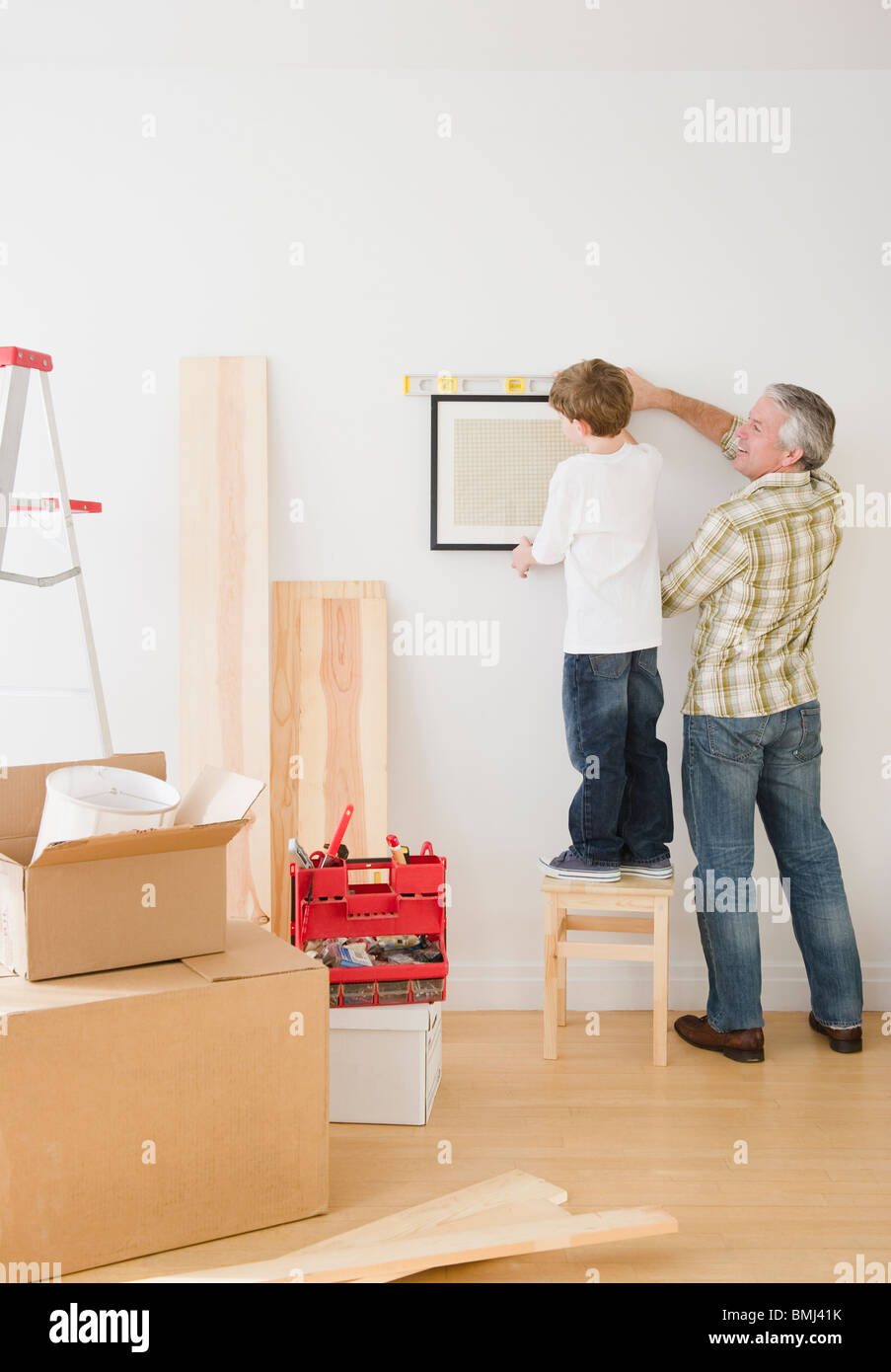 Vater und Sohn hängenden Bild an Wand Stockfoto