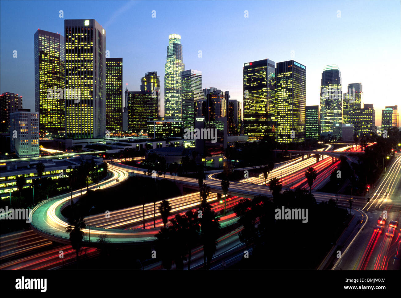 Die Skyline von Downtown Los Angeles, Kalifornien, USA, leuchtet in der Dämmerung mit Lichtern von Bürogebäuden und Autobahnverkehr. Stockfoto