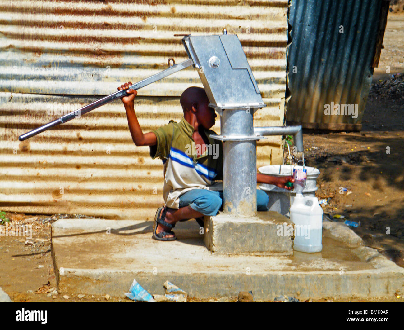 Ein Junge pumpt Wasser in die Stadt Ouanaminthe, Haiti Stockfoto