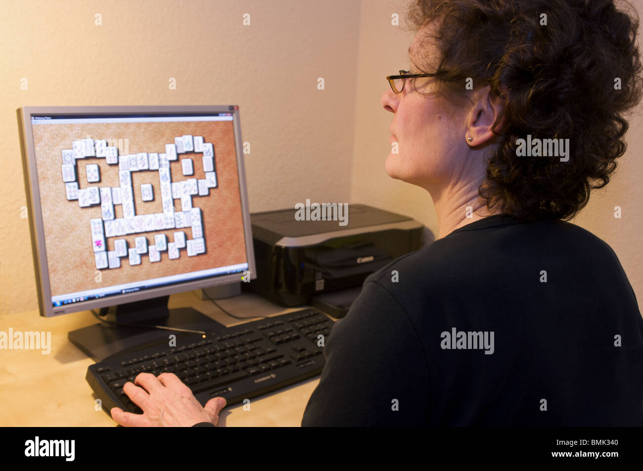 Frau spielt Mahjong-Titans Computerspiel Stockfoto