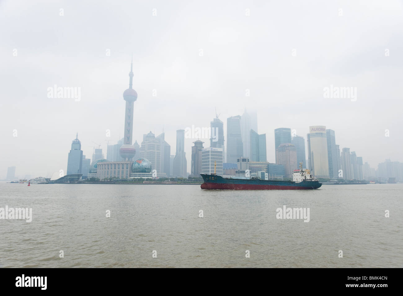 Große Schiff, das auf dem Huangpu-Fluss gegen die Skyline der Stadt Shanghai, China Stockfoto