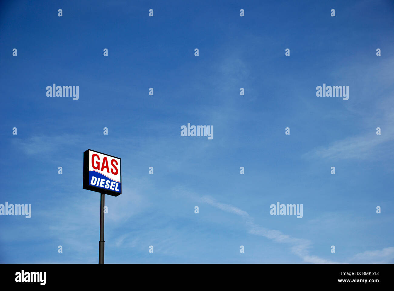 Tankstelle Schild mit den Worten Benzin und Diesel an einem langen Mast gegen blauen Himmel. Stockfoto