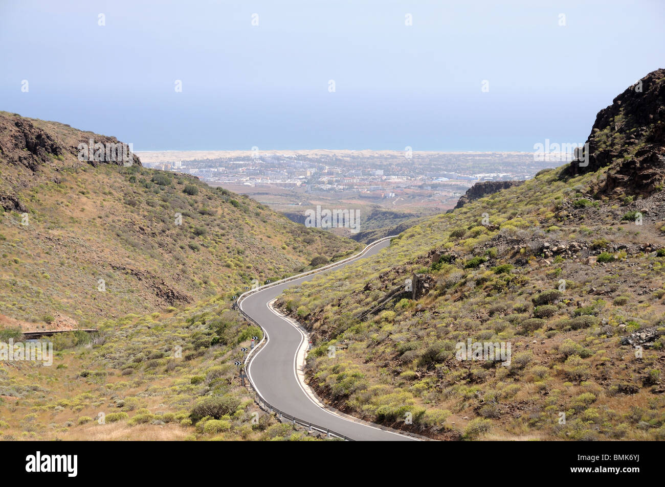 Die Bergstraße führt an der Küste von Maspalomas. Grand Kanarische Inseln, Spanien Stockfoto