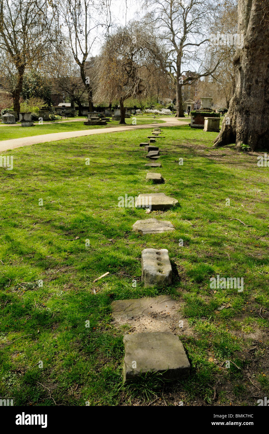 Fragmente von Grabsteinen markieren die Grenze zwischen zwei Friedhöfe, St Georges Gärten Bloomsbury Camden London England UK Stockfoto
