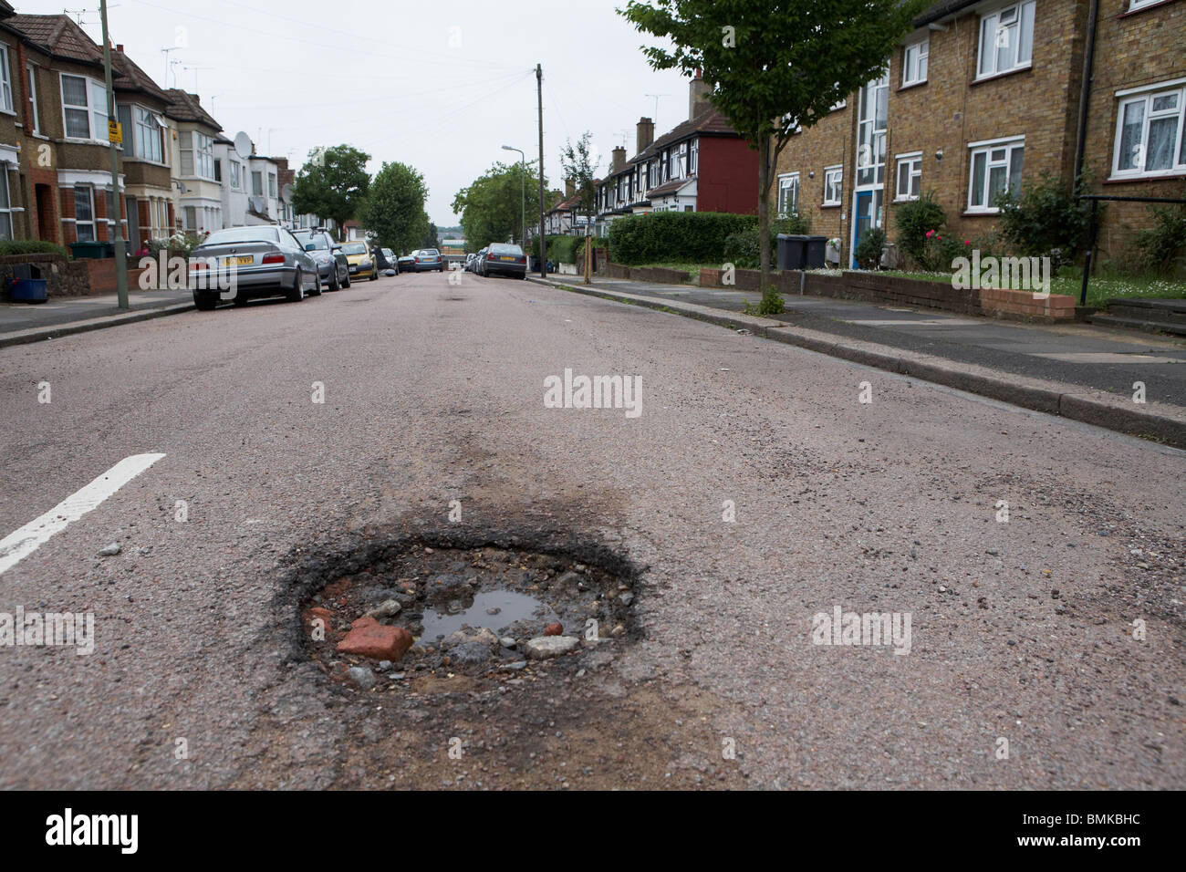 Schlaglöcher in einer Vorstadt Straße in Nord-London Stockfoto