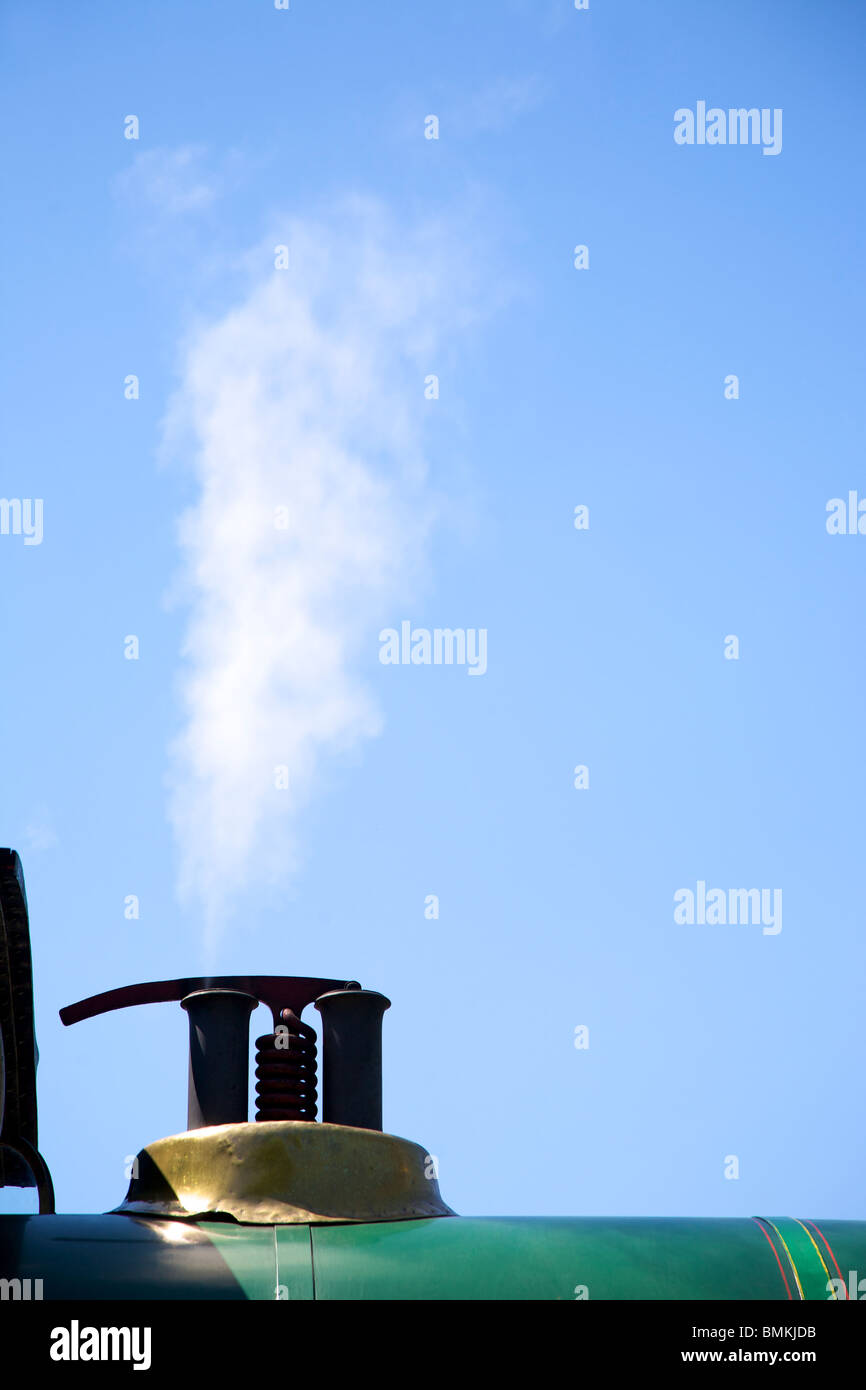 Dampf aus dem Überdruckventil auf einer Eisenbahn Dampflokomotive gesetzt vor blauem Himmel Stockfoto