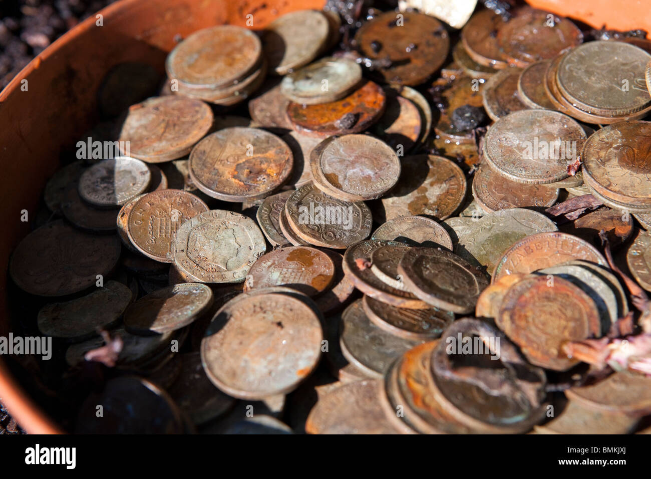 Ein Topf schmutzig und rostigen englische Münzen, meist zwei und einem Pence-Stücke Stockfoto