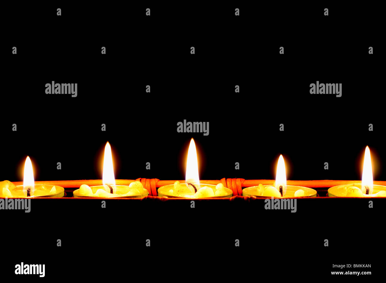 Reihe von Kerzen auf schwarzem Hintergrund Stockfoto