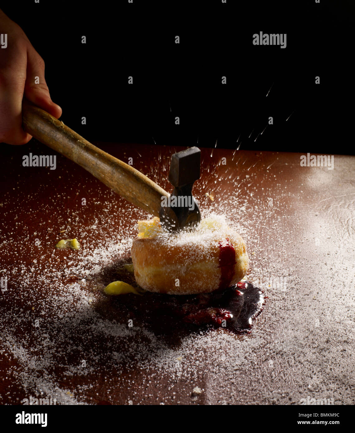 Donut wird mit einem Hammer zerschlagen Stockfoto Donut wird mit einem Hammer zerschlagen Stockfoto