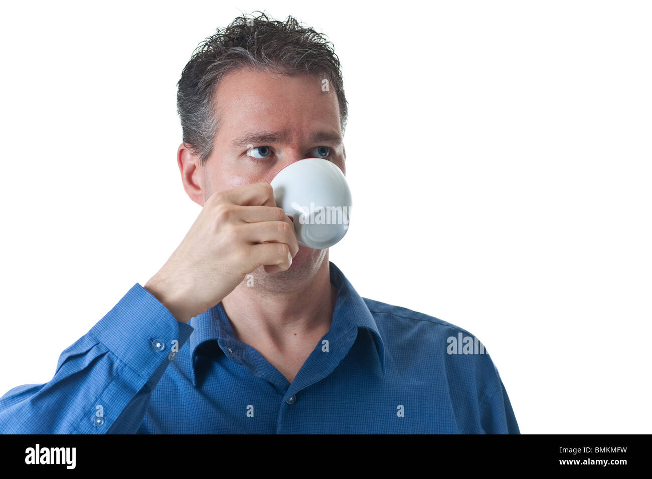 Ein Mann in einem blauen Kleid Shirt, trinken aus einem kleinen Cappuccino / Coffee Cup, isoliert auf weiss. Stockfoto