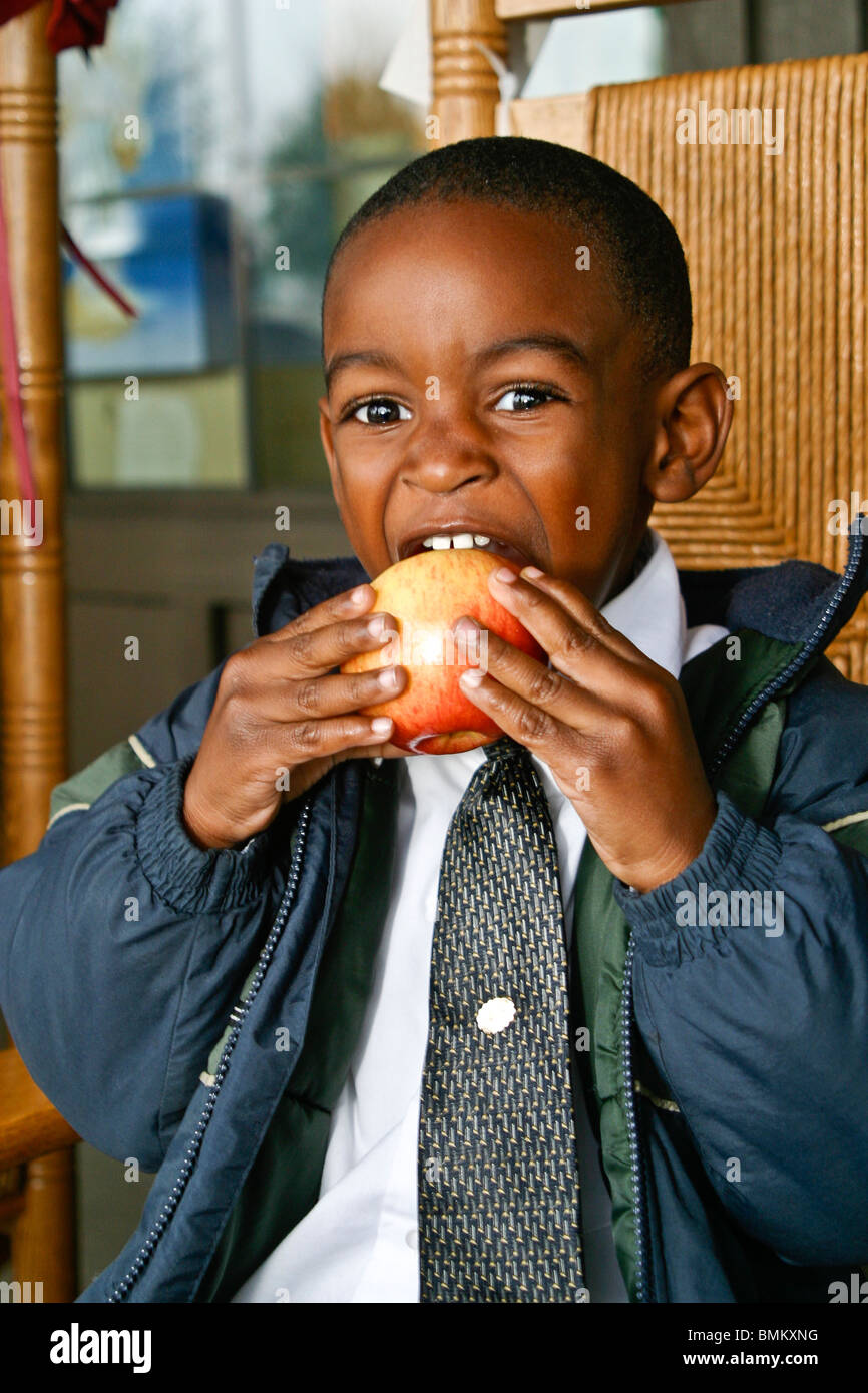 African American Boy in weißem Hemd und Krawatte Jacke Essen Apfel vor Cracker Barrel laden und Restaurant Florida Herr © Myrleen Pearson Stockfoto