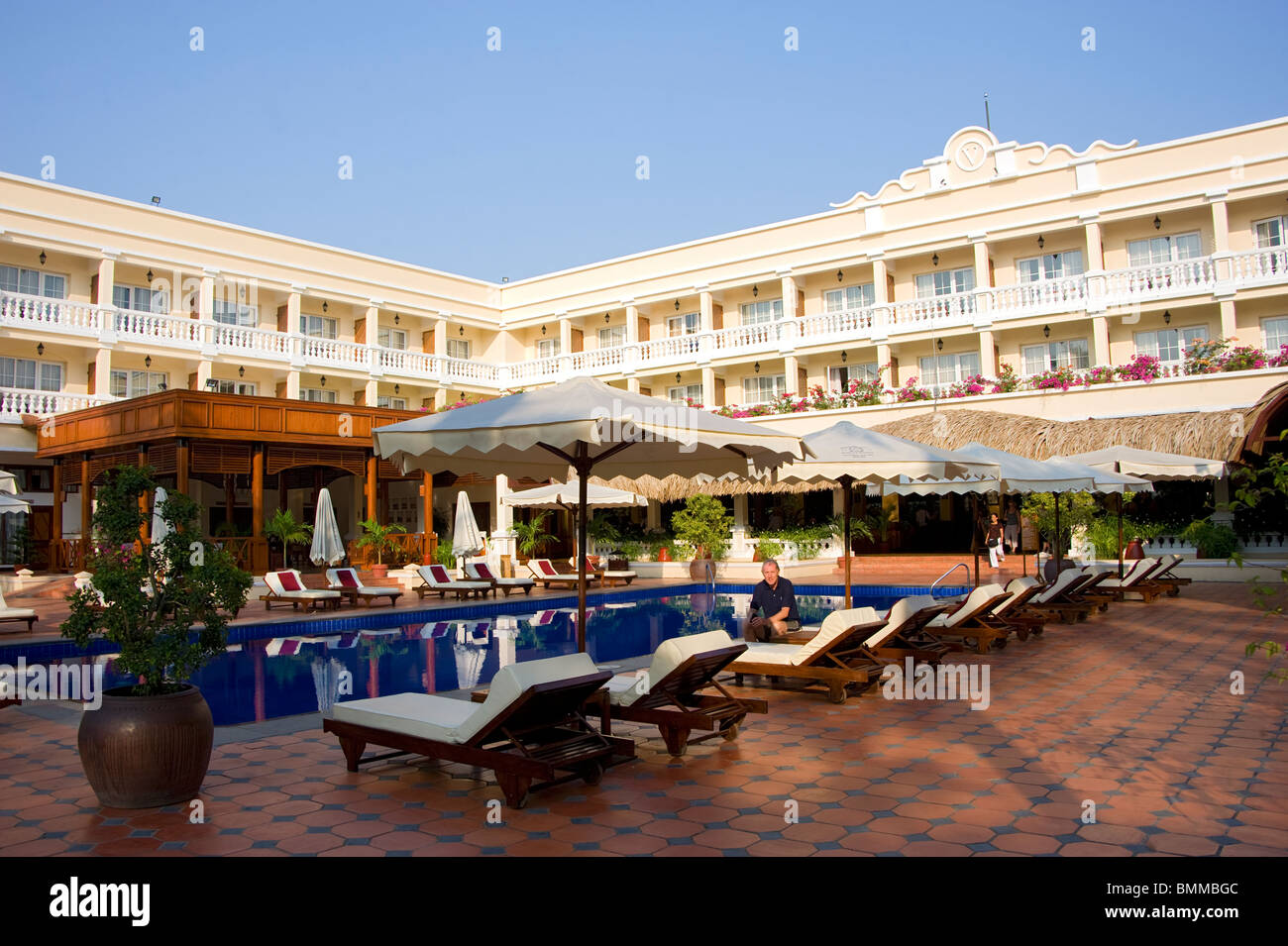 Peter Roberts auf der Sonnenliege am Pool des Hotel Victoria Can Tho, Vietnam Stockfoto