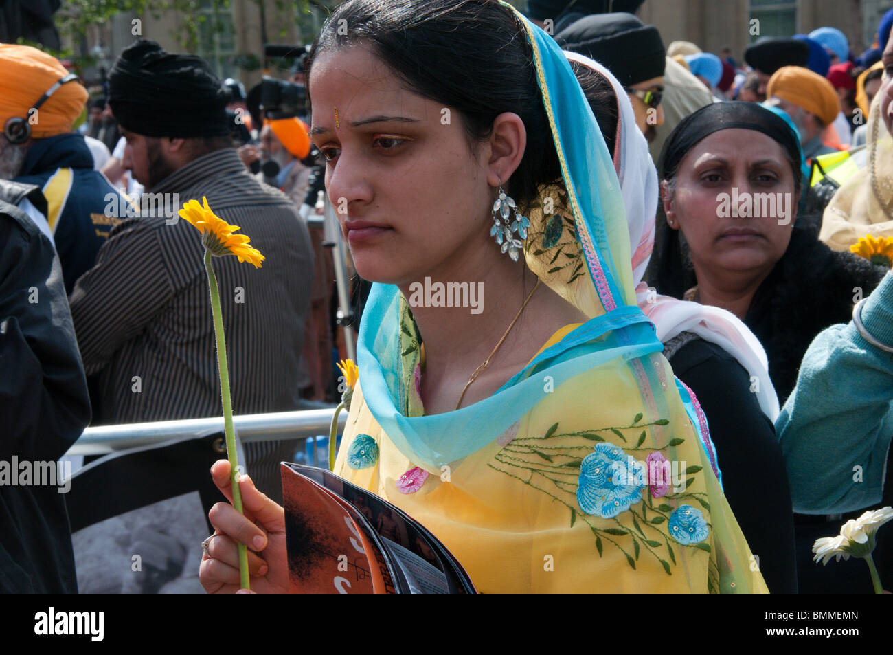 Sikh Frau hält Blume in Linie es in Hommage an Toten in 1984 indischen Massakern zu verlegen.  London, UK. 13.06.2010 Stockfoto