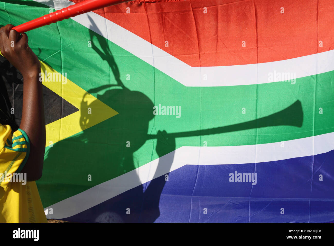 Schatten der Fußball-Fan bläst die Vuvuzela, südafrikanische Flagge im Hintergrund, Johannesburg, Südafrika Stockfoto