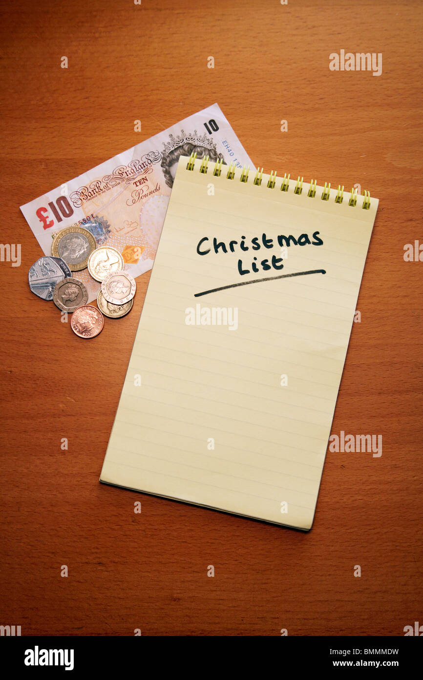 Christmas Shopping List auf farbigen Spirale gebunden Pad mit Geld: Metapher; Knapp bei Kasse Stockfoto